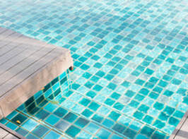 Blue and green tile pool bottom with light colored wood decking.